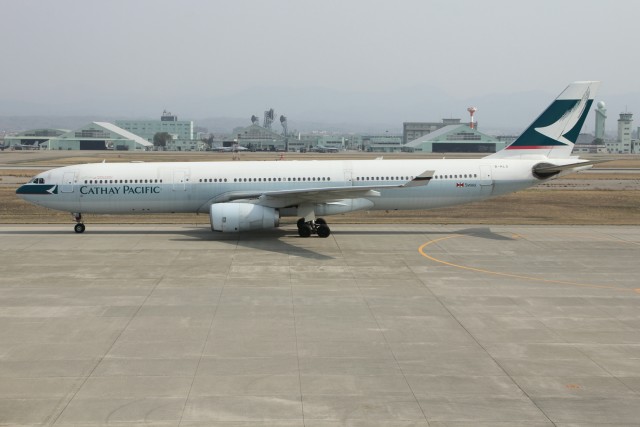 小松空港に着陸したキャセイパシフィック航空の香港便（バックは航空自衛隊小松基地）