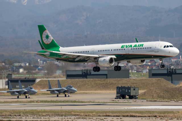 小松空港に着陸するエバー航空の台北便（バックは航空自衛隊小松基地のＦ－１５）